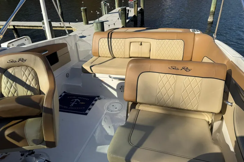 Slide: The Image of 2015 Sea Ray 240 Sundeck interior with tan leather seating and dock view. - 21