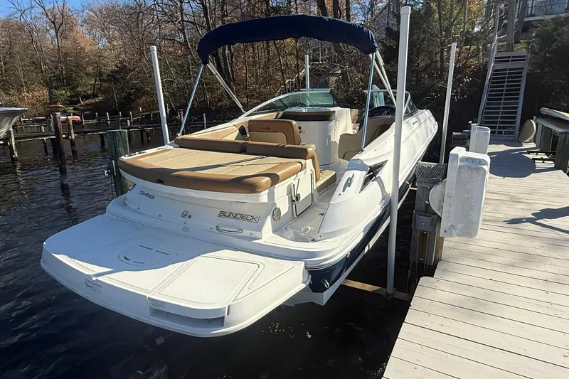 Slide: The Image of 2015 Sea Ray 240 Sundeck boat docked, featuring spacious seating and sleek design. - 5