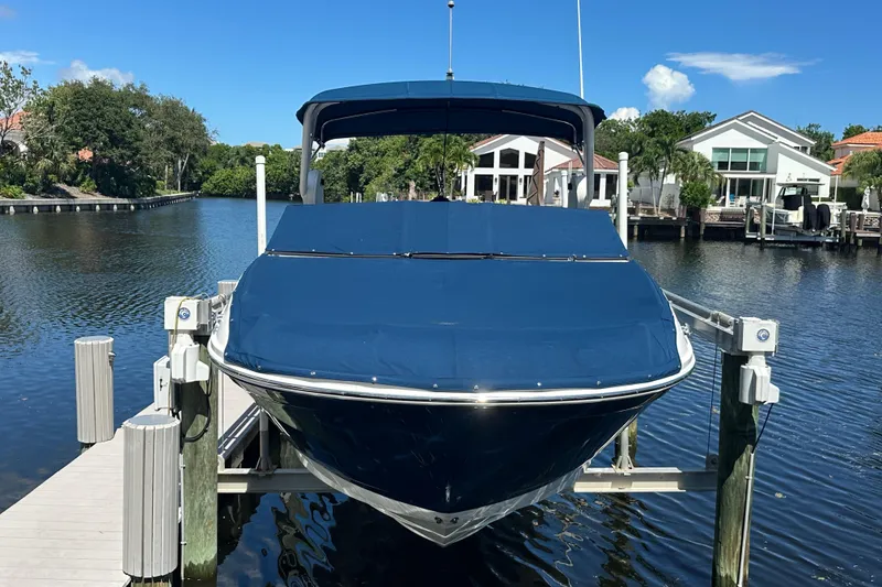 Slide: The Image of 2019 Sea Ray SDX 270 Outboard boat docked on a sunny waterfront. - 2