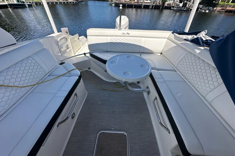 Slide: The Image of 2019 Sea Ray SDX 270 Outboard boat interior with white seating and round table. - 4