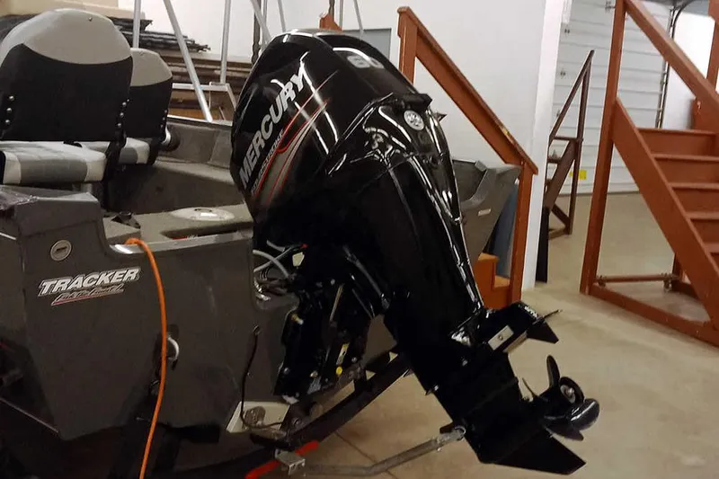 Slide: The Image of 2018 Tracker Pro Guide V-16 SC boat with Mercury outboard motor in a garage. - 2