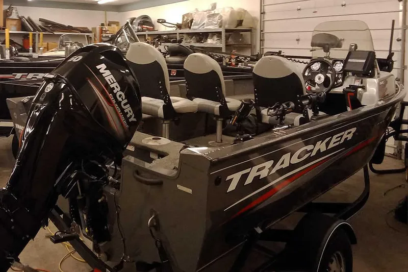 Slide: The Image of 2018 Tracker Pro Guide V-16 SC boat with Mercury outboard motor in a garage. - 27