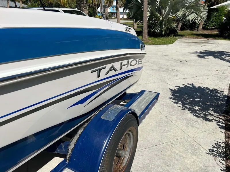 Slide: The Image of 2005 Tahoe T18 Ski Boat on trailer, parked outdoors in sunny setting. - 18