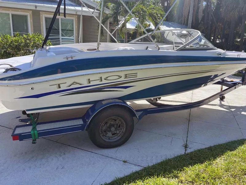 The Image of 2005 Tahoe T18 Ski Boat on trailer, parked in driveway, sunny day. - 2