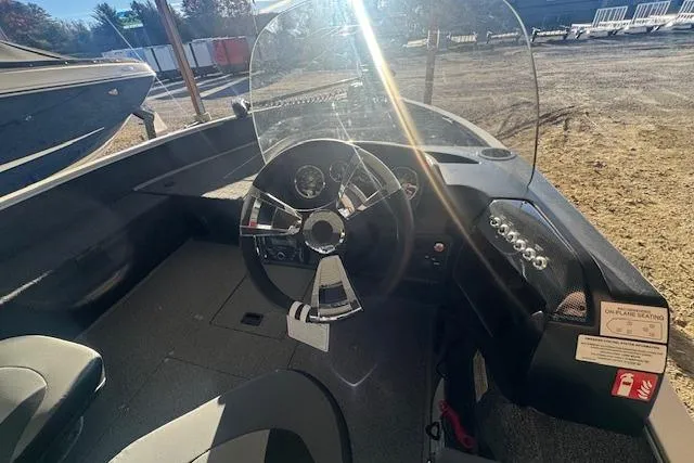 Slide: The Image of 2026 Lowe Fishing Machine 1625SC boat interior with steering wheel and dashboard controls. - 11