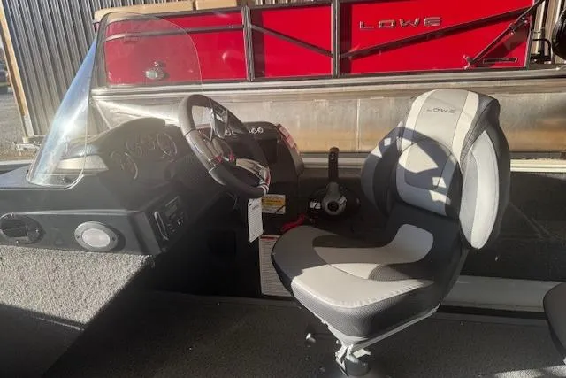 Slide: The Image of 2026 Lowe Fishing Machine 1625SC boat interior with steering wheel and seat. - 15