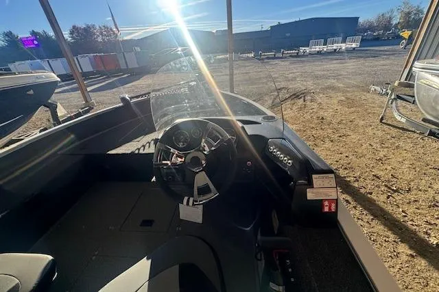 Slide: The Image of 2026 Lowe Fishing Machine 1625SC boat interior with steering wheel and dashboard in sunlight. - 17