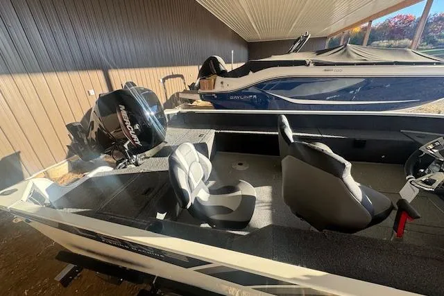 Slide: The Image of 2026 Lowe Fishing Machine 1625SC boat with Mercury engine in a storage area. - 27