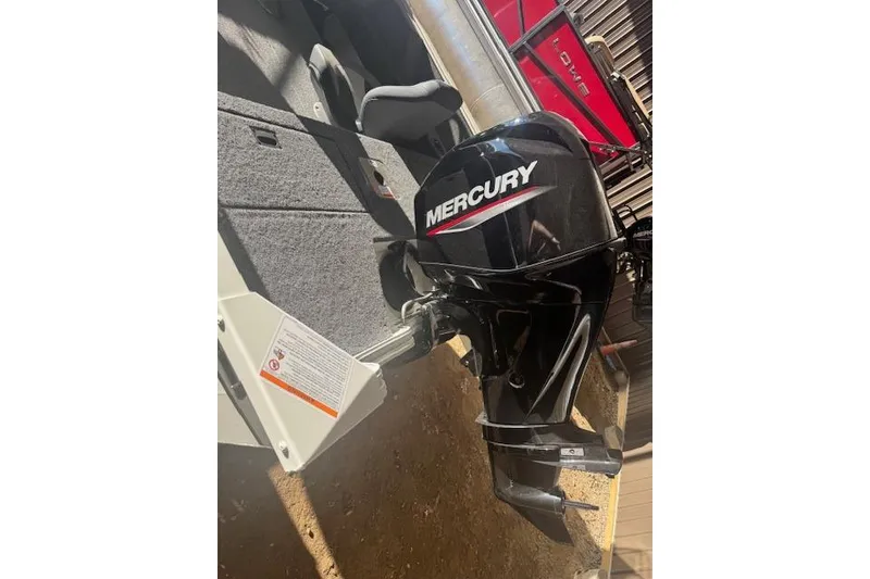 Slide: The Image of 2026 Lowe Fishing Machine 1625SC with Mercury outboard motor in a garage setting. - 31