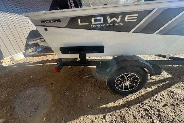 Slide: The Image of 2026 Lowe Fishing Machine 1625SC boat on trailer, side view in sunlight. - 9