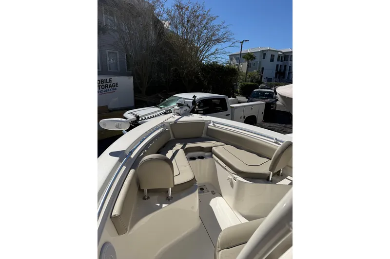 Slide: The Image of 2021 Key West 239 FS boat with seating, parked outdoors near vehicles. - 10