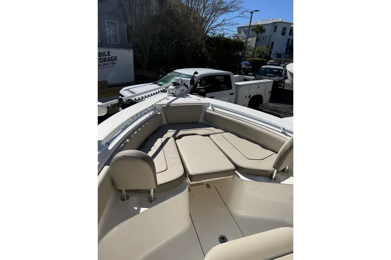 Slide: The Image of 2021 Key West 239 FS boat with beige seating, parked near a white truck. - 11