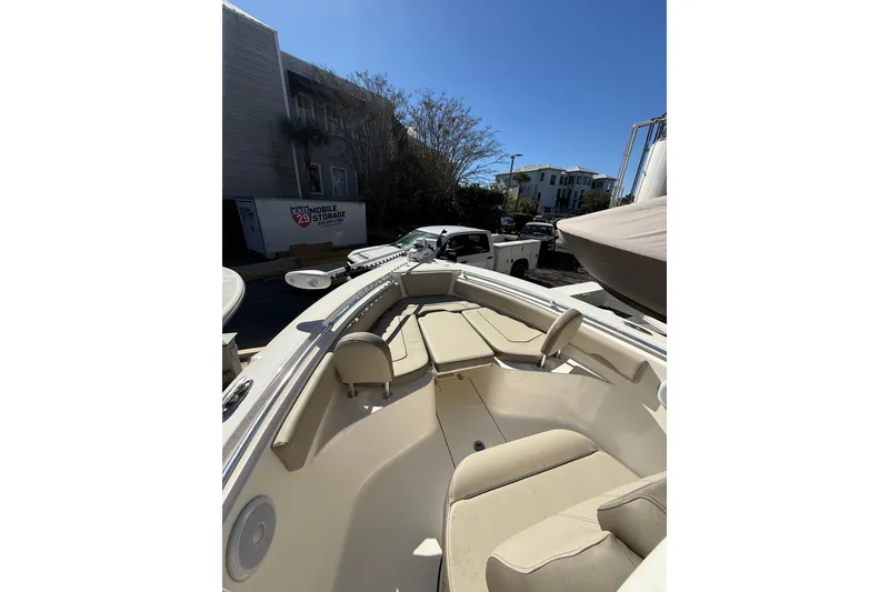 Slide: The Image of 2021 Key West 239 FS boat interior with beige seating, parked outdoors. - 12