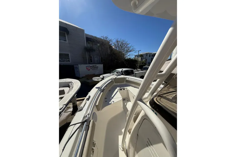 Slide: The Image of 2021 Key West 239 FS boat docked, showcasing sleek design and spacious deck under clear blue sky. - 14