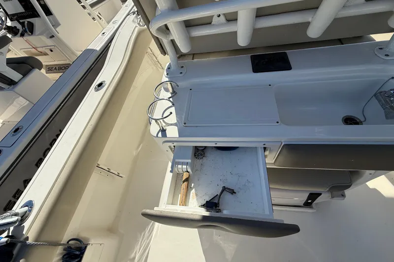 Slide: The Image of 2021 Key West 239 FS boat interior with open storage drawer and cup holders. - 18