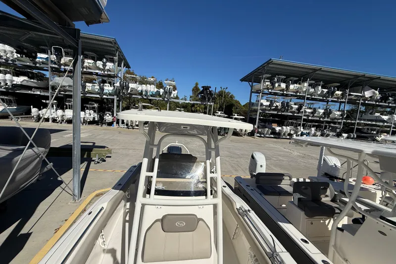 Slide: The Image of 2021 Key West 239 FS boat in marina storage, surrounded by stacked vessels under clear blue sky. - 24