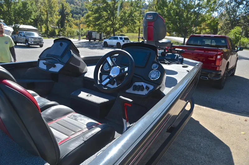 Slide: The Image of 2022 Ranger RT198P boat interior with steering wheel and dashboard, parked near a red truck. - 19