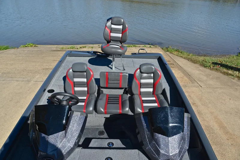 Slide: The Image of 2022 Ranger RT198P boat with sleek seats and steering, docked by a calm lake. - 23