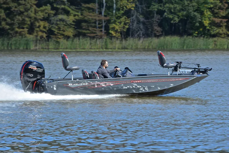 Slide: The Image of 2022 Ranger RT198P boat speeding on a lake with trees in the background. - 3