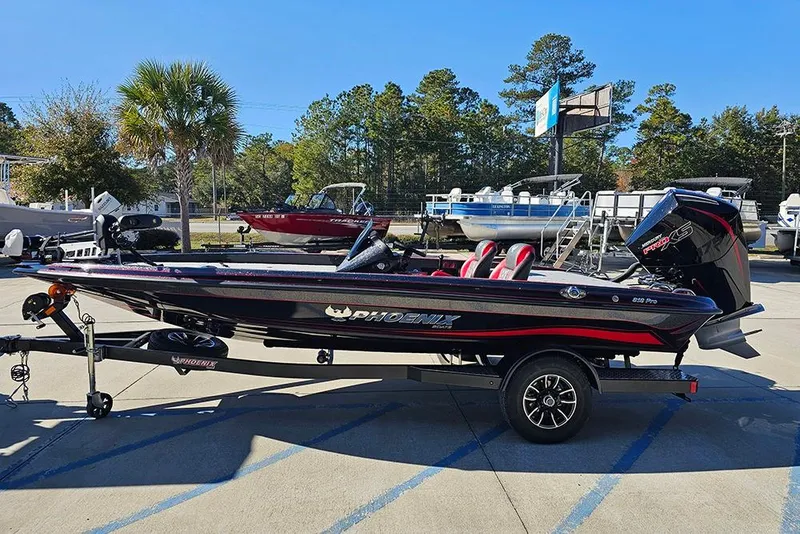 Slide: The Image of 2026 Phoenix 818 Pro boat on trailer, parked outdoors with trees in background. - 6