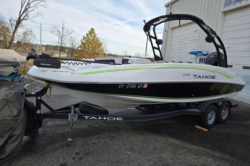 Slide: The Image of 2018 Tahoe 2150 boat on trailer, parked outdoors near a building. - 1