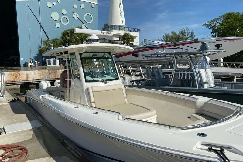 The Image of 2019 Boston Whaler 330 Outrage boat docked at marina under clear blue sky. - 0