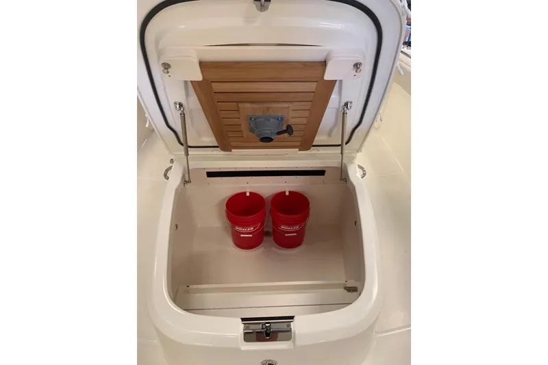 Slide: The Image of Open storage compartment on 2019 Boston Whaler 330 Outrage with red buckets inside. - 15