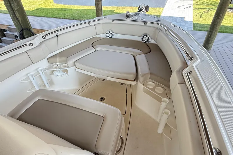 Slide: The Image of 2023 Boston Whaler 230 Outrage boat interior with cushioned seating and cup holders. - 11