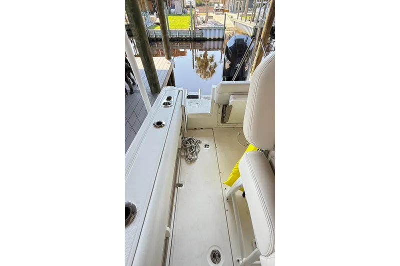 Slide: The Image of 2023 Boston Whaler 230 Outrage boat interior with seating and dock view. - 13