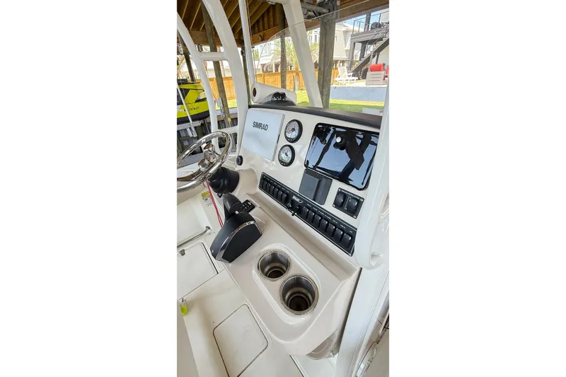 Slide: The Image of 2023 Boston Whaler 230 Outrage boat console with steering wheel and Simrad display. - 3