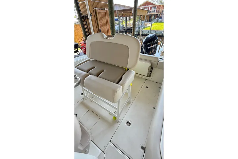 Slide: The Image of 2023 Boston Whaler 230 Outrage boat interior with cushioned seating and deck view. - 6