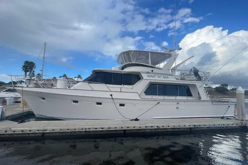 The Image of 1990 Offshore Yachts 55 Pilothouse docked under a partly cloudy sky. - 0