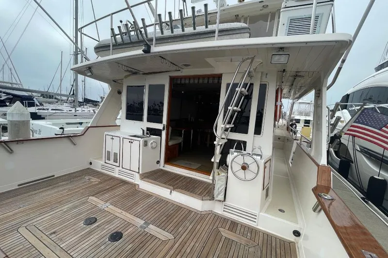 Slide: The Image of 1990 Offshore Yachts 55 Pilothouse with spacious deck and marina view. - 1