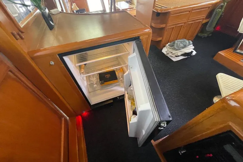 Slide: The Image of Interior of 1990 Offshore Yachts 55 Pilothouse with open mini fridge. - 10
