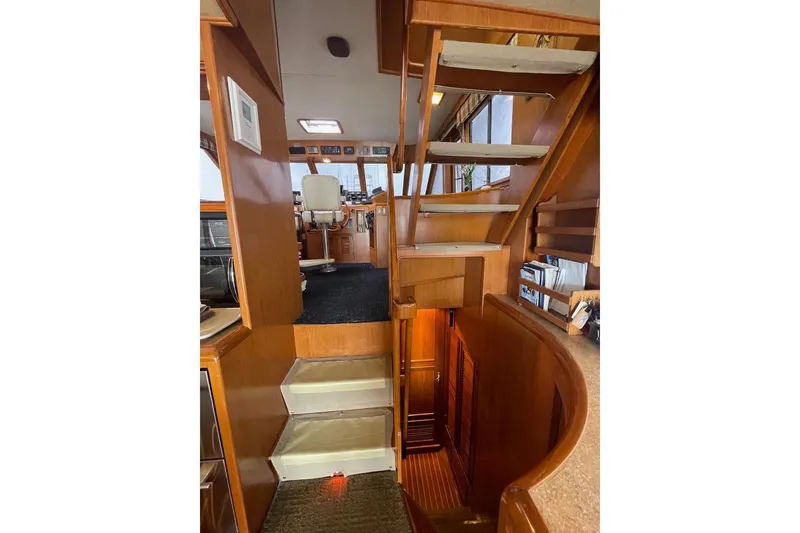 Slide: The Image of Interior view of 1990 Offshore Yachts 55 Pilothouse, featuring wooden stairs and pilothouse area. - 11