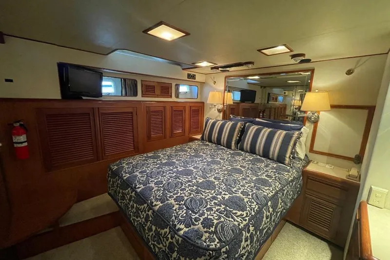 Slide: The Image of Luxurious bedroom in 1990 Offshore Yachts 55 Pilothouse with elegant bedding and wood accents. - 17