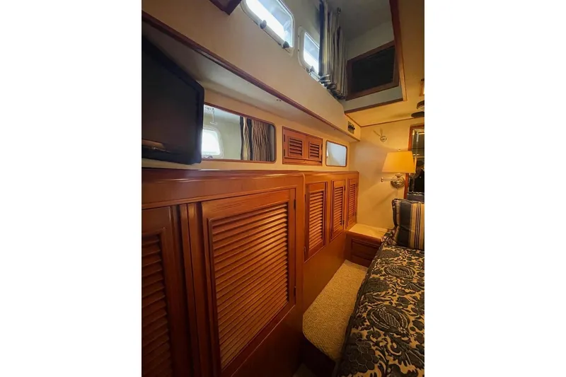 Slide: The Image of Interior of 1990 Offshore Yachts 55 Pilothouse with wood paneling and cozy furnishings. - 18