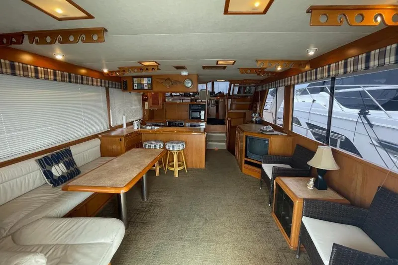 Slide: The Image of Interior of 1990 Offshore Yachts 55 Pilothouse with cozy seating and wooden furnishings. - 2