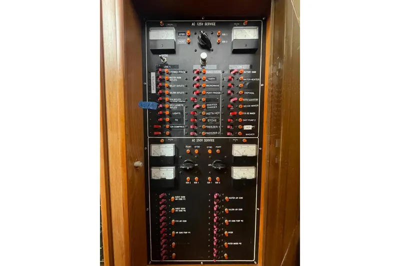 Slide: The Image of Electrical panel of a 1990 Offshore Yachts 55 Pilothouse, featuring various switches and meters. - 26