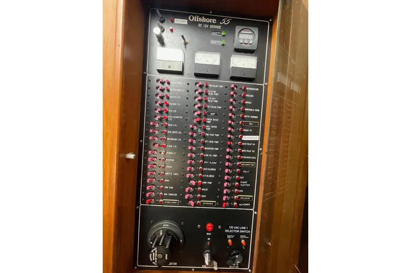 Slide: The Image of Electrical panel of 1990 Offshore Yachts 55 Pilothouse, featuring various switches and gauges. - 27