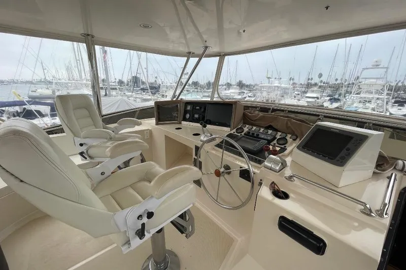 Slide: The Image of Pilothouse interior of 1990 Offshore Yachts 55, featuring dual captain chairs and navigation equipment. - 30
