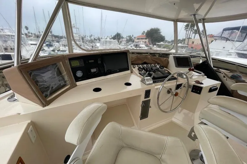 Slide: The Image of Pilothouse interior of 1990 Offshore Yachts 55, featuring navigation equipment and steering wheel. - 32