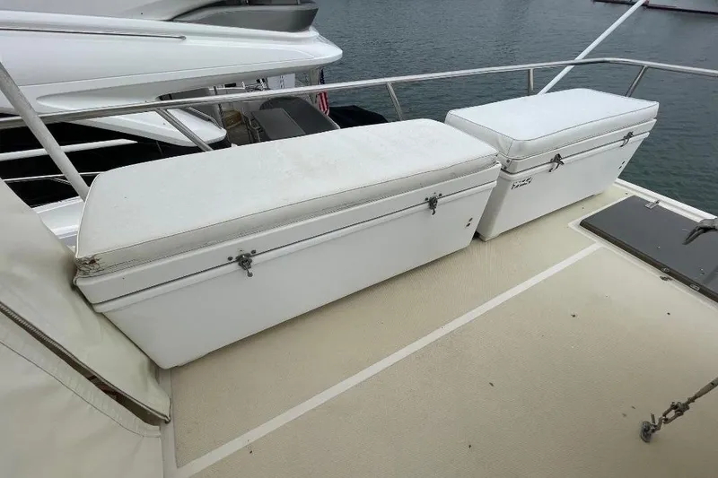 Slide: The Image of 1990 Offshore Yachts 55 Pilothouse deck with white storage benches. - 42