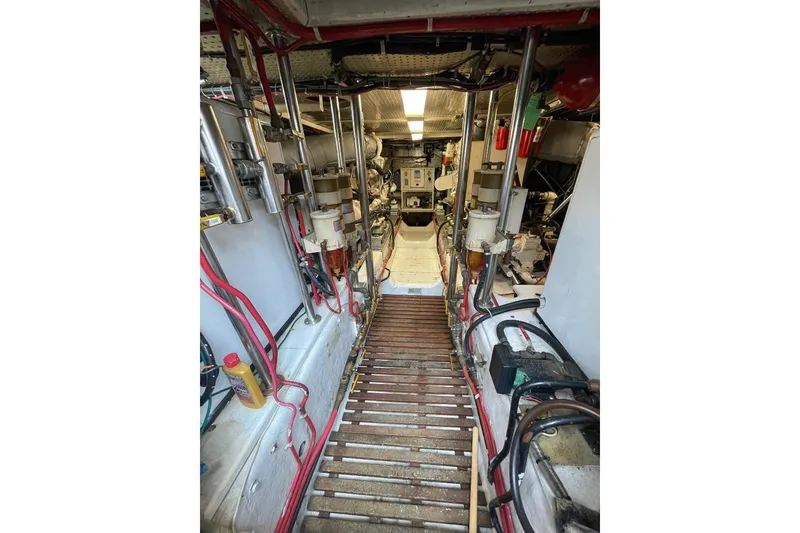 Slide: The Image of Engine room of 1990 Offshore Yachts 55 Pilothouse, showcasing mechanical components and wiring. - 45