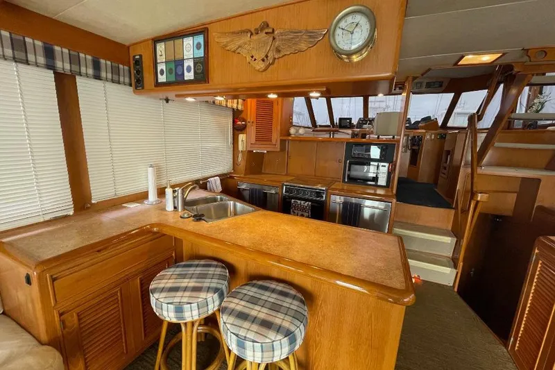 Slide: The Image of Interior of 1990 Offshore Yachts 55 Pilothouse with kitchen and seating area. - 5
