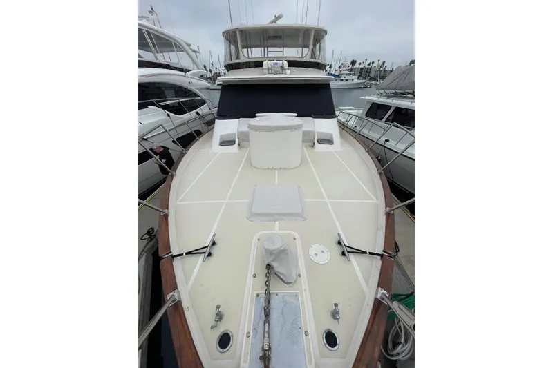 Slide: The Image of 1990 Offshore Yachts 55 Pilothouse, docked, showcasing spacious deck and pilothouse. - 55