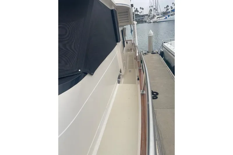 Slide: The Image of Side view of 1990 Offshore Yachts 55 Pilothouse docked at marina. - 56