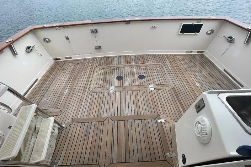Slide: The Image of 1990 Offshore Yachts 55 Pilothouse deck with teak flooring and ocean view. - 58