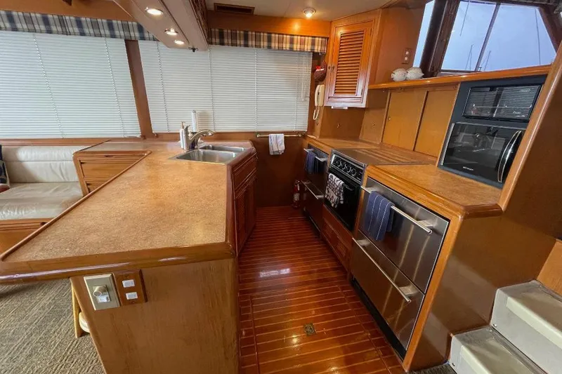 Slide: The Image of Luxurious 1990 Offshore Yachts 55 Pilothouse kitchen with modern appliances and wood finishes. - 6