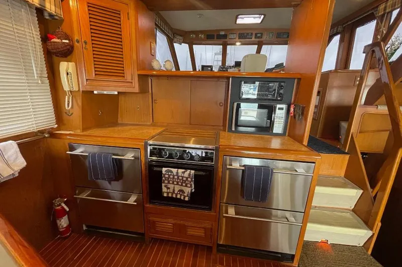 Slide: The Image of 1990 Offshore Yachts 55 Pilothouse kitchen with wood cabinetry and modern appliances. - 7